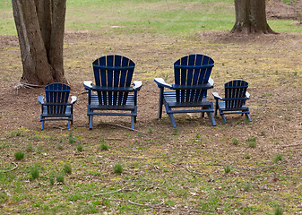 Image showing Four adirondack chairs in forest