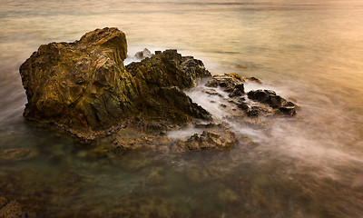 Image showing Long exposure sunset on sea rocks