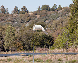 Image showing Old white wind sock by paved road