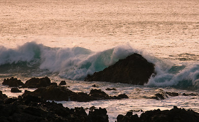 Image showing Crashing waves on rock in sunset