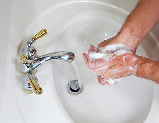 Image showing Senior male wash hands with soap