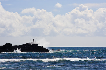 Image showing Silhouette of a fisherman on rocky headland