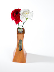 Image showing Red and white spray carnations in teak vase