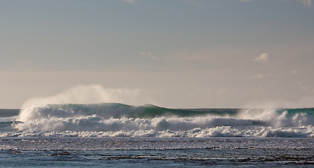 Image showing Waves breaking on the reef off a sandy beach