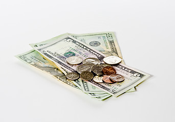 Image showing Coins stacked on dollar bills