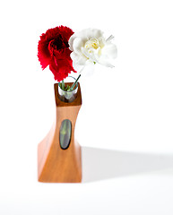 Image showing Red and white spray carnations in teak vase