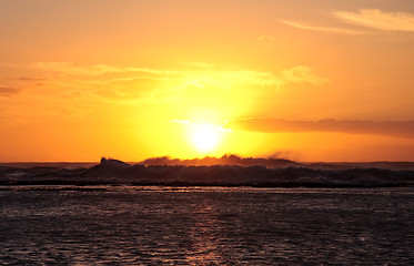 Image showing Sun setting over breaking waves off coast of Hawaii