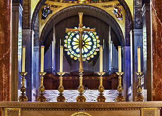 Image showing Ornate candlesticks on altar in church with gold cross