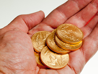 Image showing Hand holding stack of gold coins