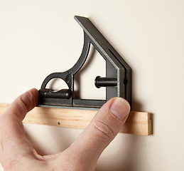 Image showing Leveling a small frame on wall