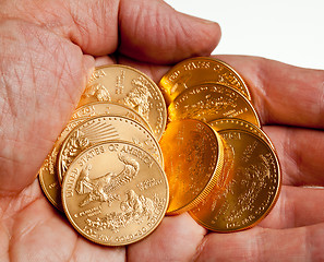 Image showing Hand holding stack of gold coins