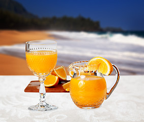 Image showing Glass of orange on the beach