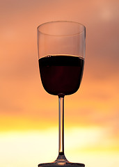 Image showing Sunset behind glass of red wine