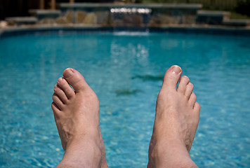 Image showing Close up of feet over pool