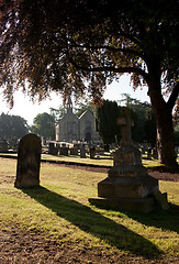 Image showing Backlit view of gravestones with church