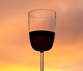 Image showing Sunset behind glass of red wine