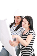 Image showing Attractive young engineer with helmet studying planes with her c