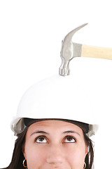 Image showing girl with safety helmet about to be hit by a hammer over a white