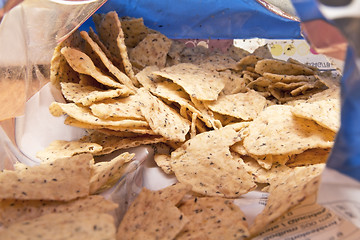 Image showing Peaking into a bag of chips