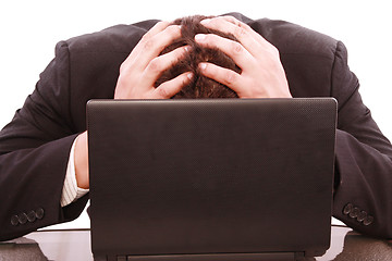 Image showing a successful business man is frustrated on a table with a laptop