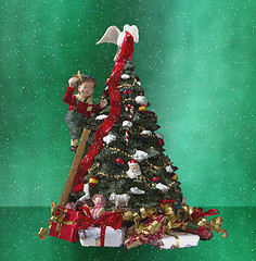 Image showing A small boy decorating a christamas tree