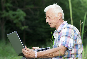 Image showing An elderly man with a laptop