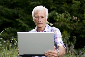 Image showing An elderly man with a laptop