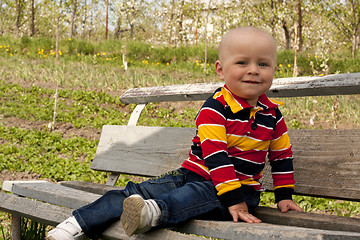 Image showing A boy sitting on a bench