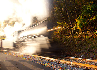 Image showing Steam train powers along railway