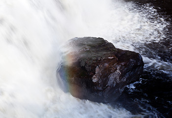 Image showing Rainbow over rock in waterfall