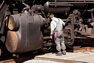 Image showing Mechanic checks locomotive