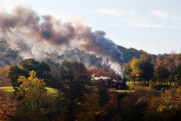 Image showing Steam train powers along railway