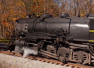 Image showing Steam train powers along railway