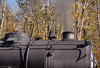 Image showing Steam train powers along railway