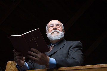 Image showing Hansom Senior Caucasian Man Holding a Hymnal in Church Pew 