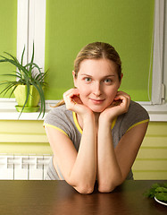 Image showing pregnant woman on kitchen smiles on camera