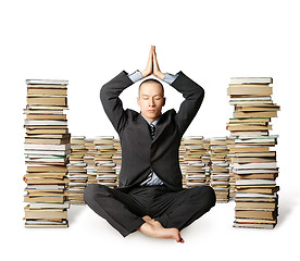 Image showing businessman in lotus pose with many books near