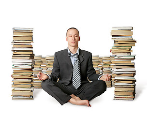 Image showing businessman in lotus pose with many books near