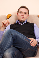 Image showing Young man relaxing in armchair