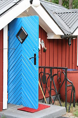 Image showing Blue door, red house