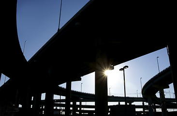 Image showing Highway ramps in silhouette with sun burst