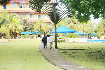 Image showing View of two gangster males talking in a backyard of a mansion