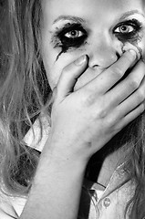 Image showing A depressed young girl covering her mouth