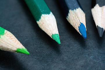 Image showing Colorful pencils on dark background lined up