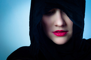 Image showing Girl in black hood against blue background