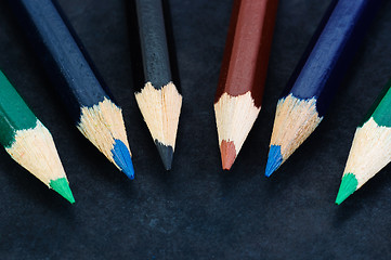 Image showing Colorful pencils on dark background lined up