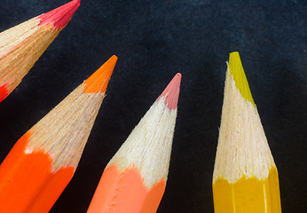 Image showing Colorful pencils on dark background lined up