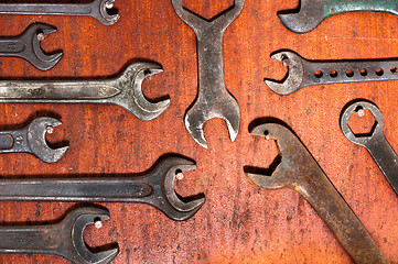 Image showing Used spanners on red wooden board