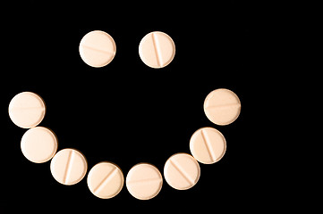 Image showing Smiling face made out of pills on black background