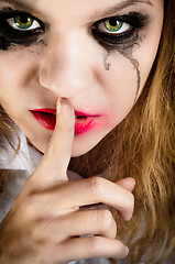 Image showing A scary looking young woman showing silence